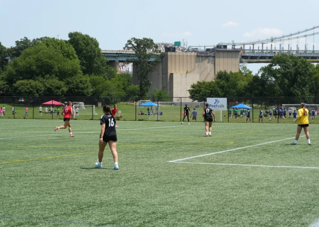 girls playing soccer on field